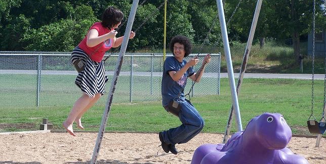 Matthew and Leslie on a swingset at the park